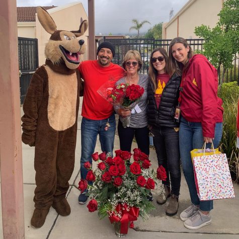 The Coyote mascot and administrators with Mrs. Rose and her 31 roses.