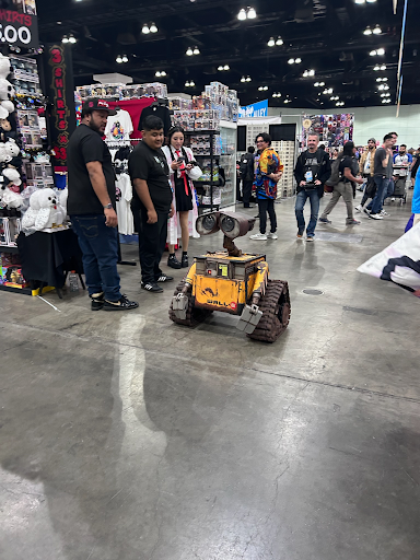 This is a remote controlled Disney character, WALL-E, driving through the aisles of the LA Comic Con.