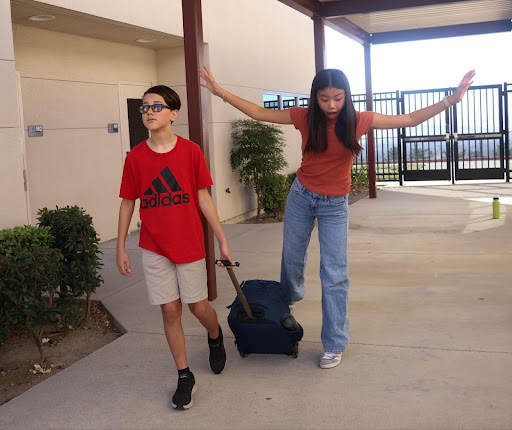 A Day Creek Coyote trips over a rolling backpack while walking through the halls.