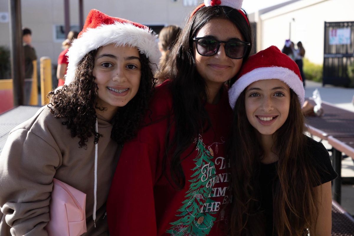 Seventh graders, Carol M., Marla H., and Natalie A., pose together ready for Christmas. 