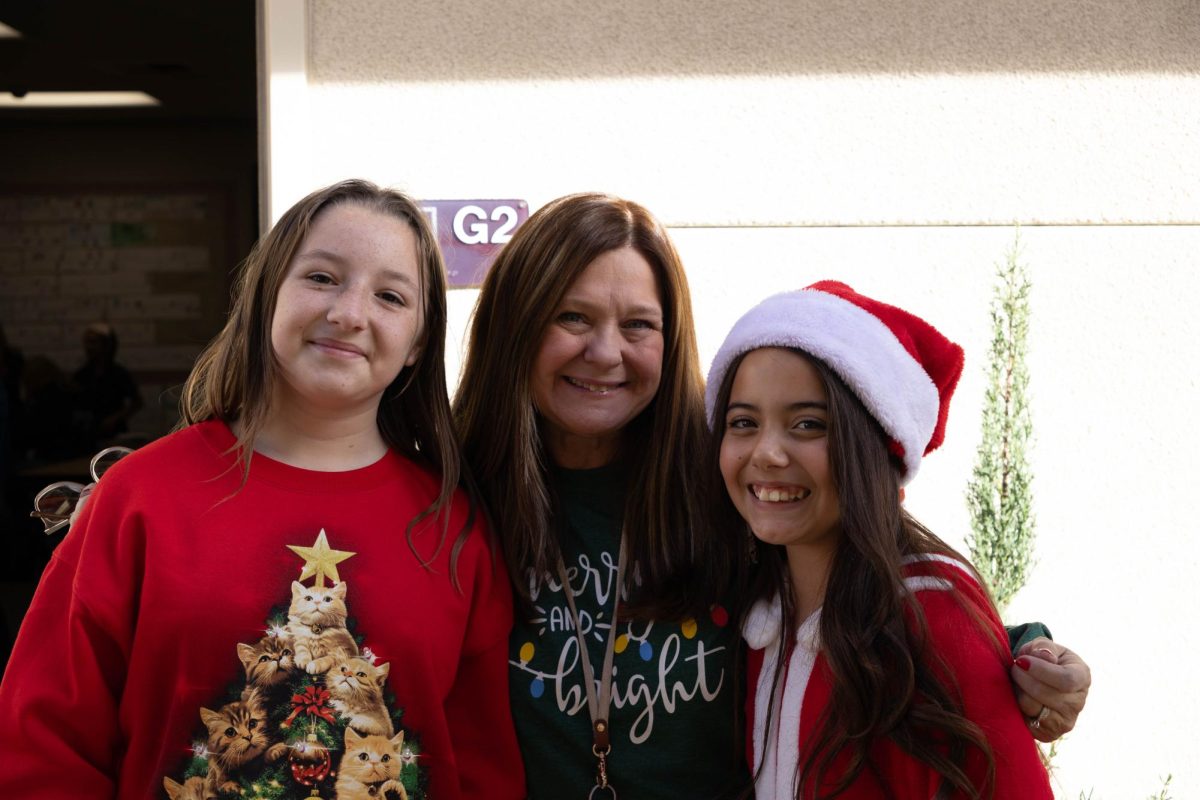 6th grade tacher Mrs. Miller and her elective students, Paisley H, Serenity P, pose together for a group photo.